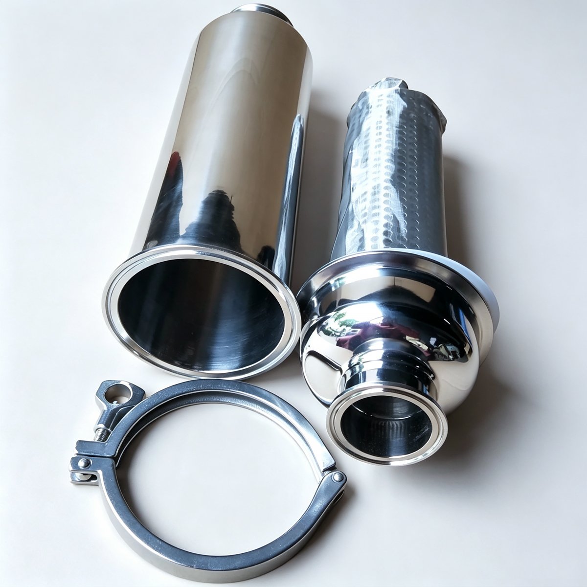 Open 304 stainless steel sanitary filter housing showing interior and separate perforated mesh filter element with tri-clamp