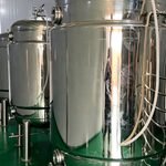 Polished stainless steel vertical process tanks with legs, pressure gauges and sanitary fittings