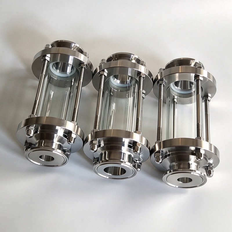 Three stainless steel sanitary inline sight glasses with transparent glass cylinders and Tri-Clamp ends